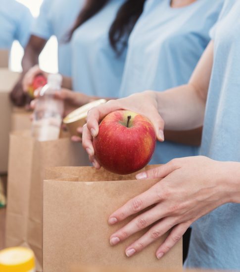 Volunteers packing food and drinks into paper bags